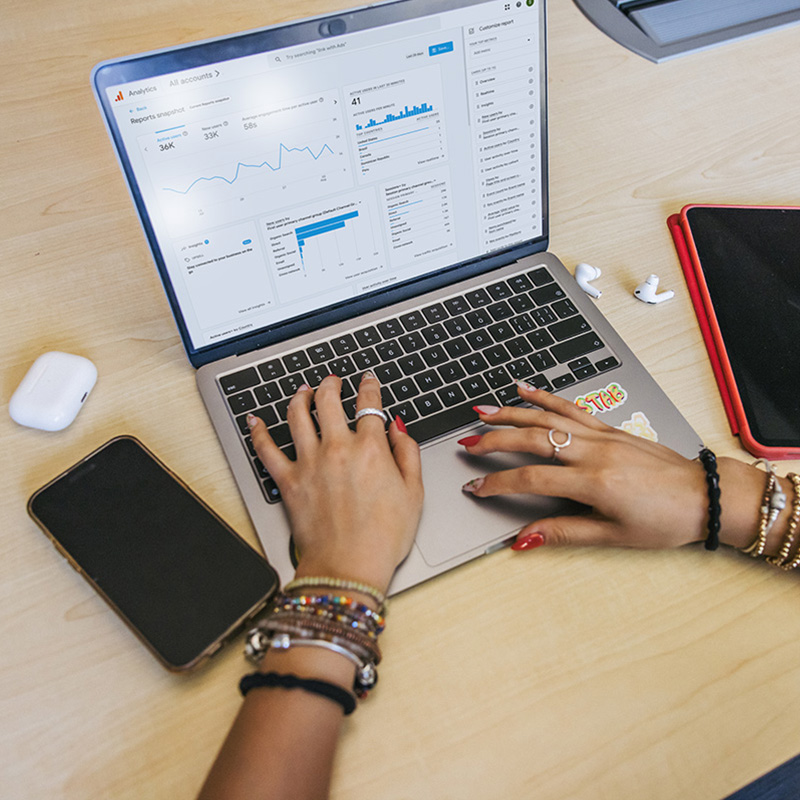 Hands work on a laptop with spreadsheets and data
