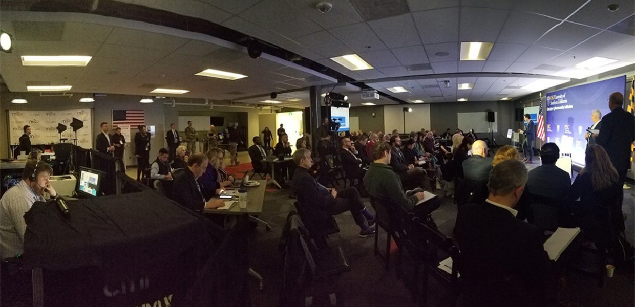 A room full of people looking at a screen and presentation.