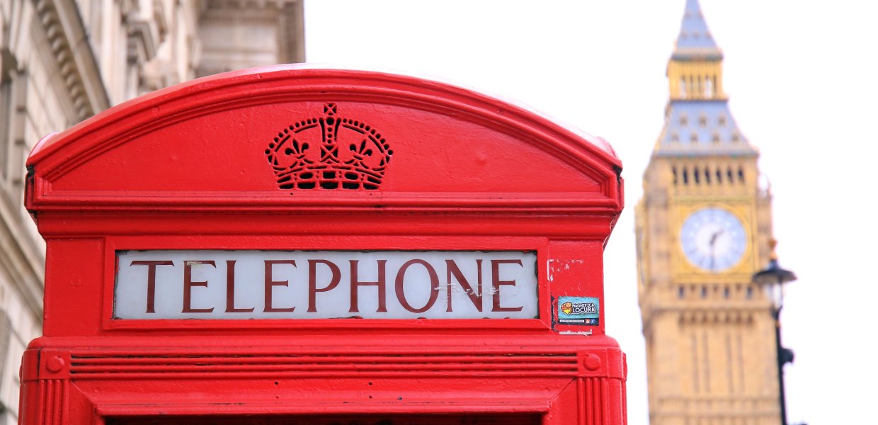 Photo of a red telephone booth next to the Big Ben in London