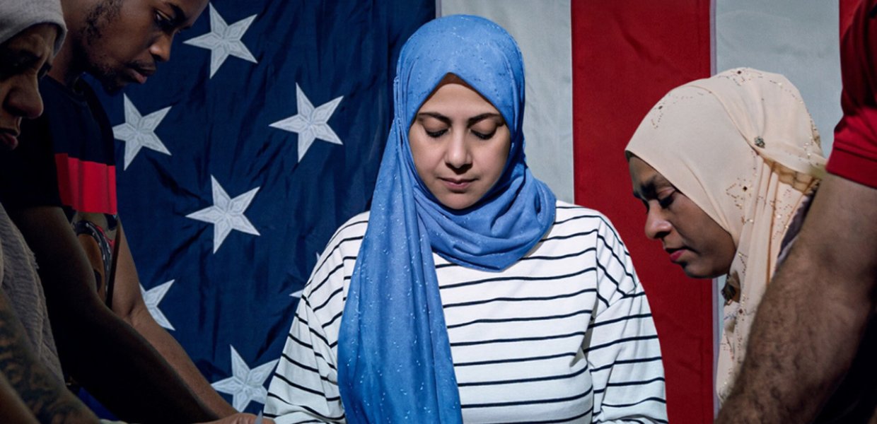 Women, wearing headscarfs, making American flags