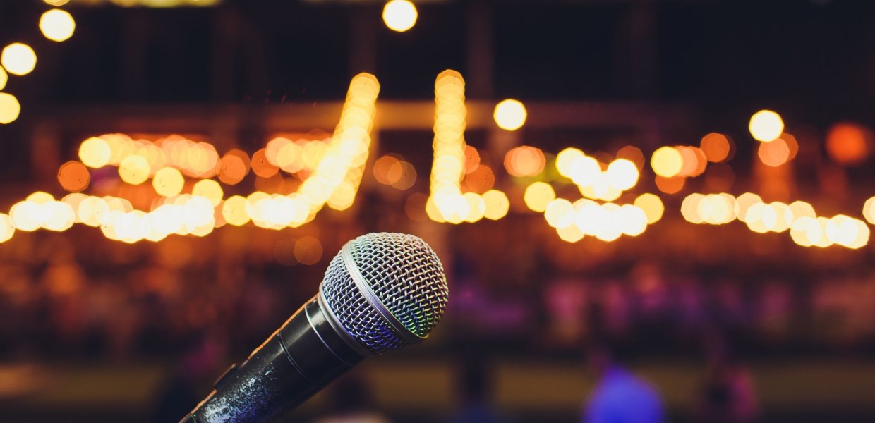 Photo of a microphone in front of an audience