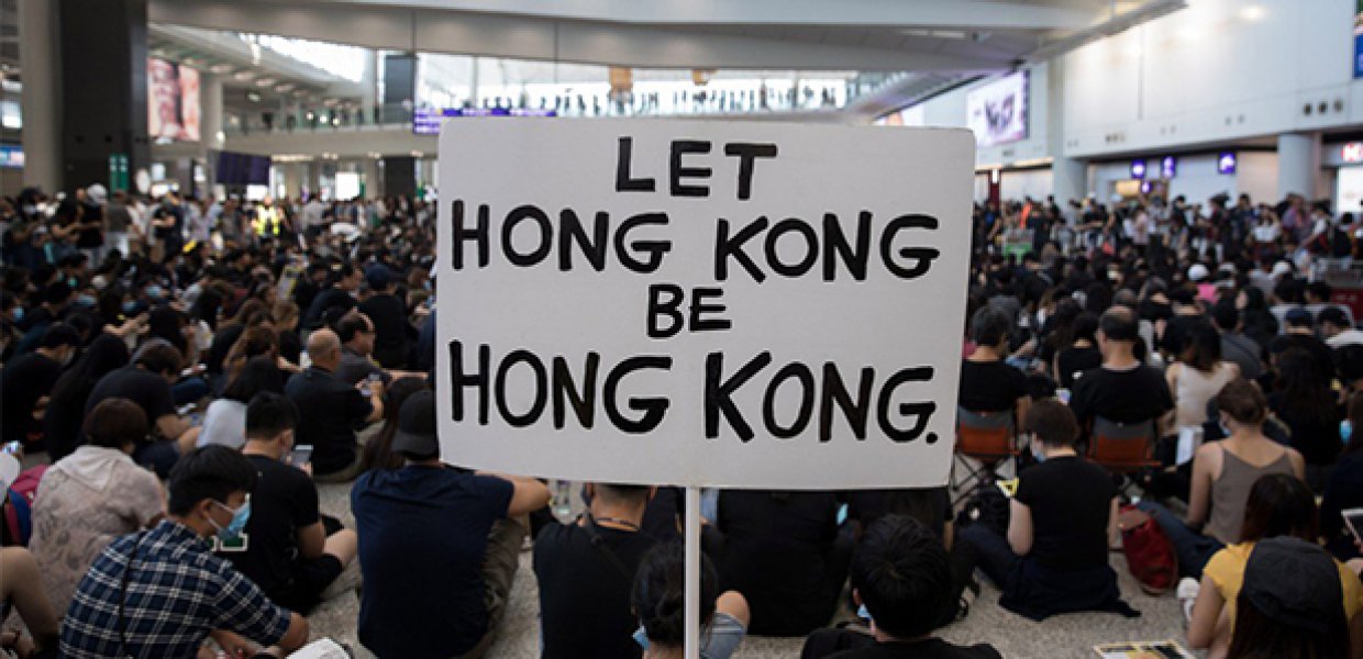 Photo of a protestor holding a sign that reads "Let Hong Kong be Hong Kong"