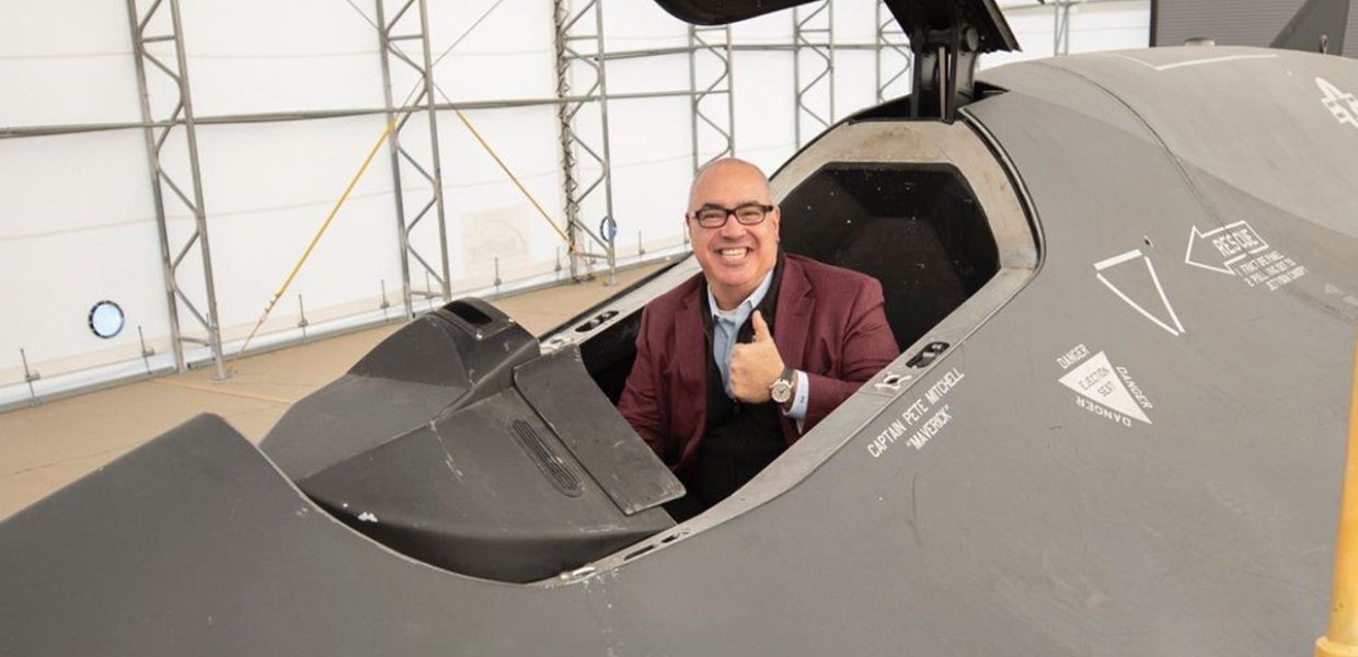 Man giving thumbs up while sitting in a seat.
