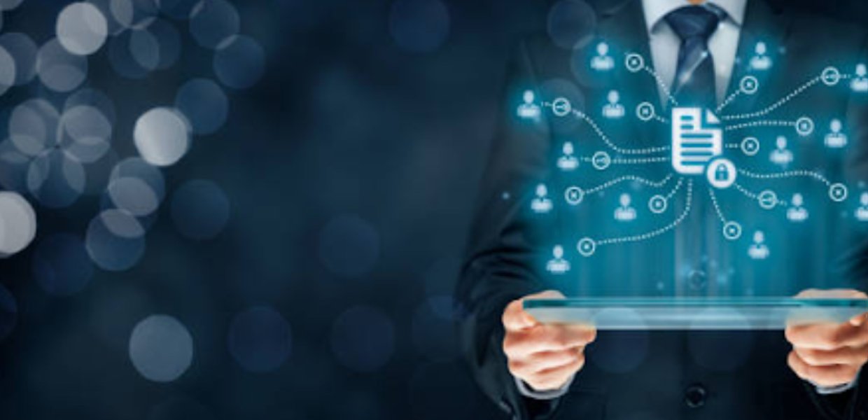 A person in a suit holding a tablet with floating glowing blue icons of people and documents above it