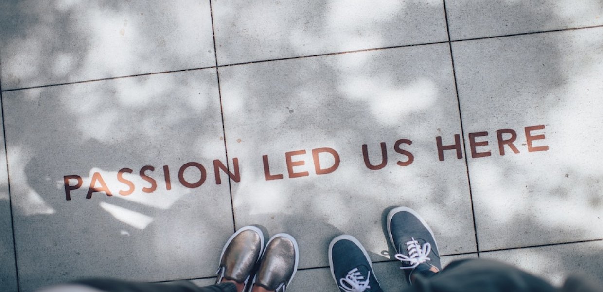 Photo of people standing next to words on the floor reading "passion led us here"