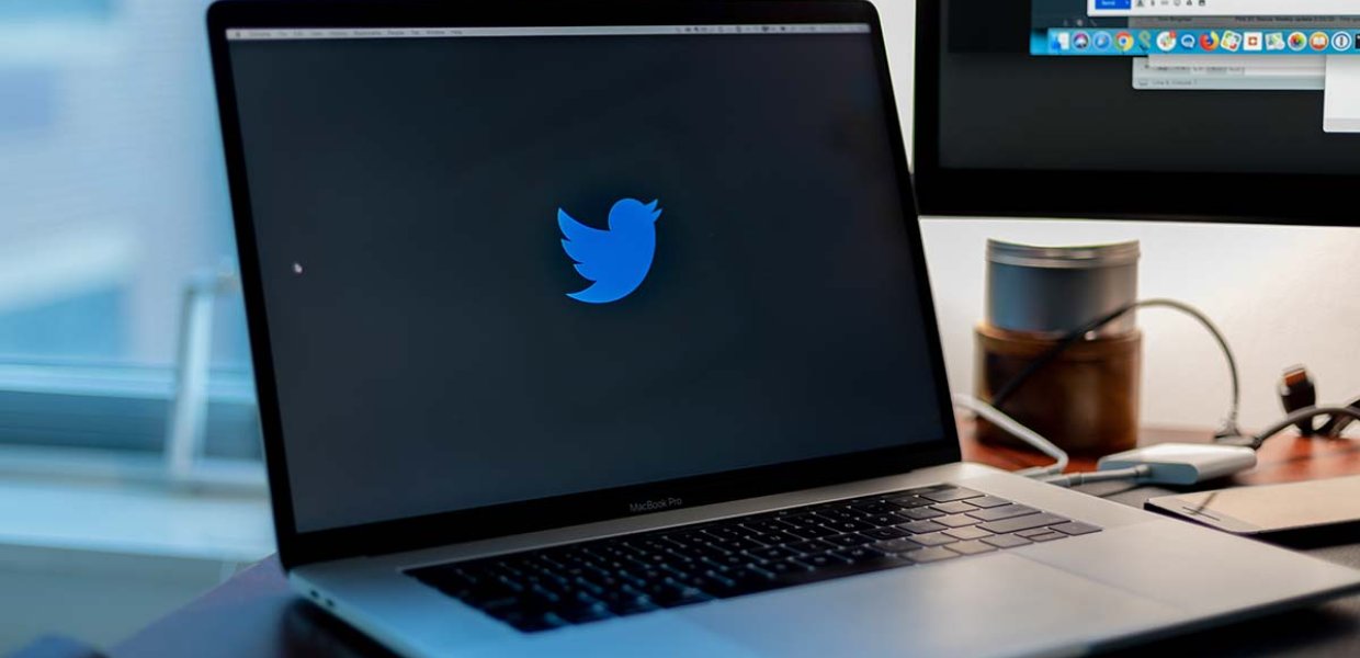 Photo of a laptop screen with the Twitter logo on it