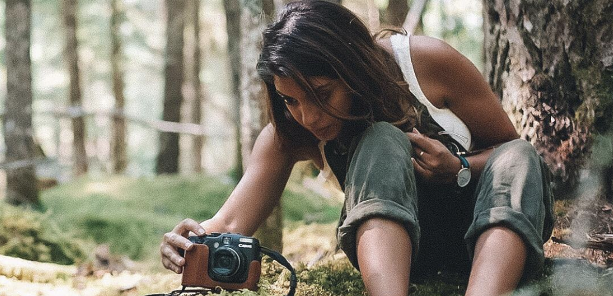 Photo of Aliya Jasmine taking a photograph in a forest