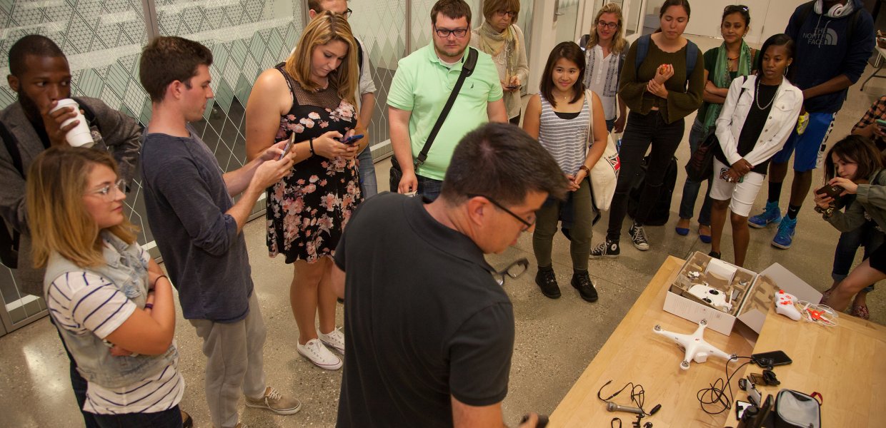 USC Annenberg professor Vince Gonzales (foreground, center) shows journalism graduate students an array of devices that enhance their phones for mobile journalism during the Summer Immersion boot camp. © USC Annenberg/Brett Van Ort