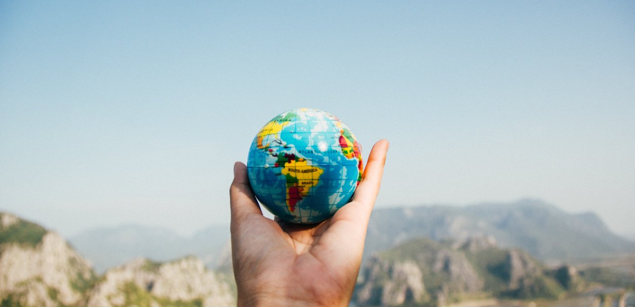 Picture of a person holding a small globe in their hand