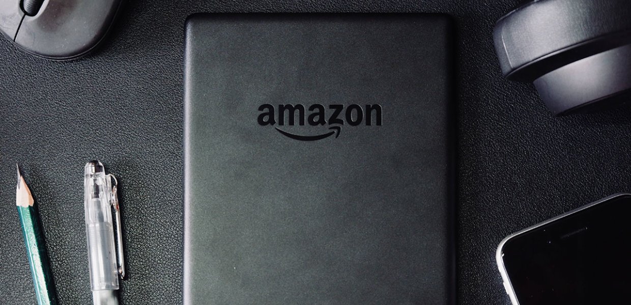 Photo of a Amazon notebook next to headphones, a mouse, and pens