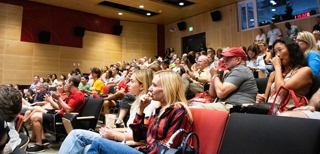 An audience watching intently in an ASC auditorium
