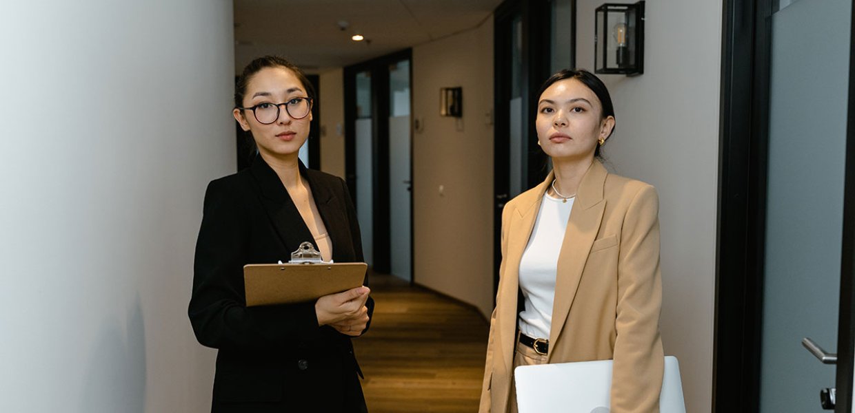Photo of two Asian women standing in a hallway