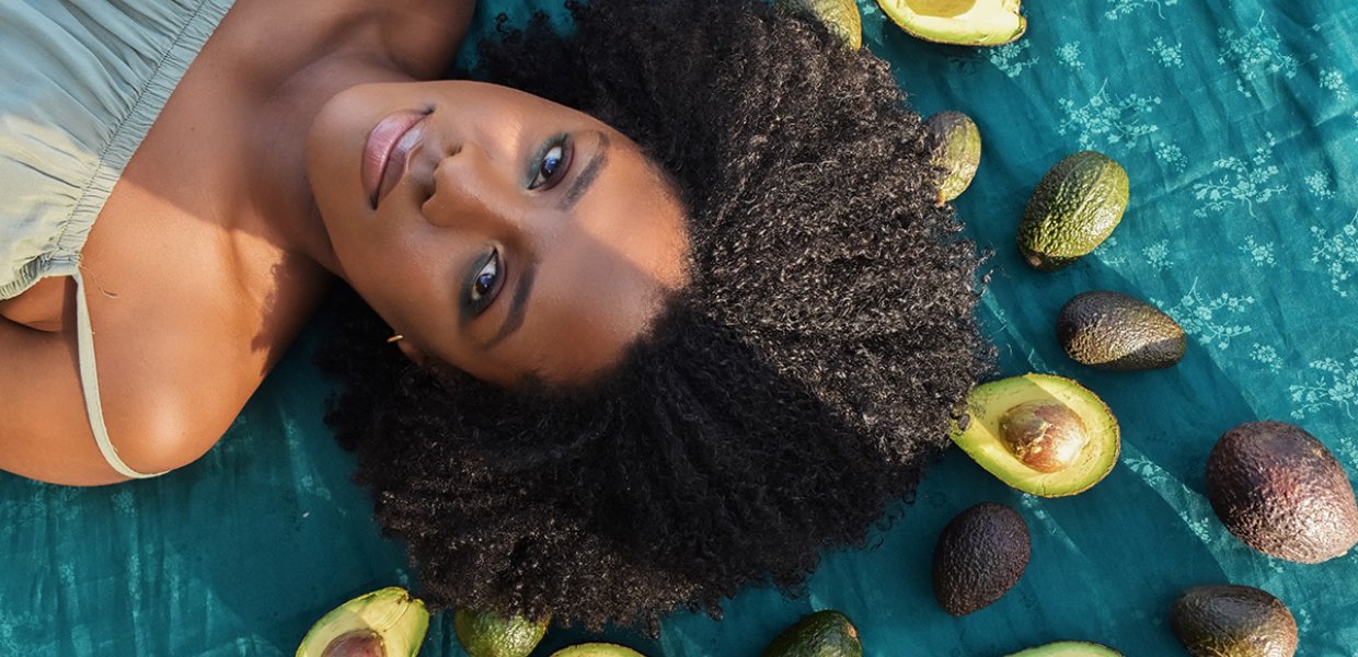 Photo of Megan V. Green lying near some avocados