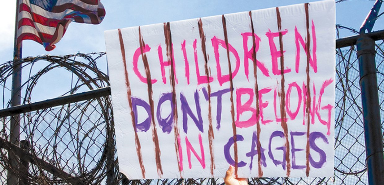 Photo of a sign that reads "children don't belong in cages"