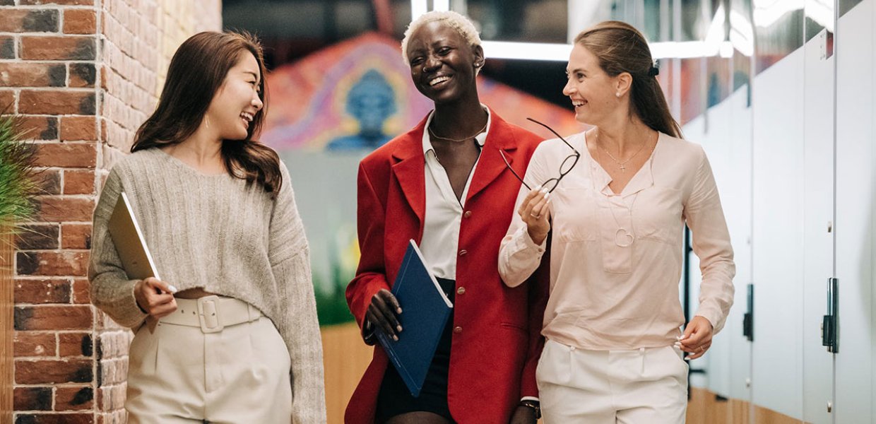 Photo of three people engaging in a gleeful conversation