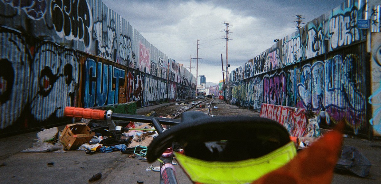 A POV shot of a bicycle riding down a Los Angeles alleyway