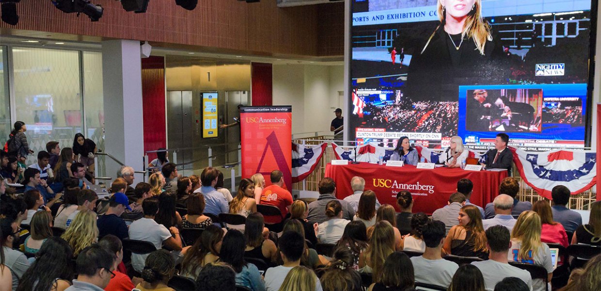 Photo of a room filled with people watching the election on screen