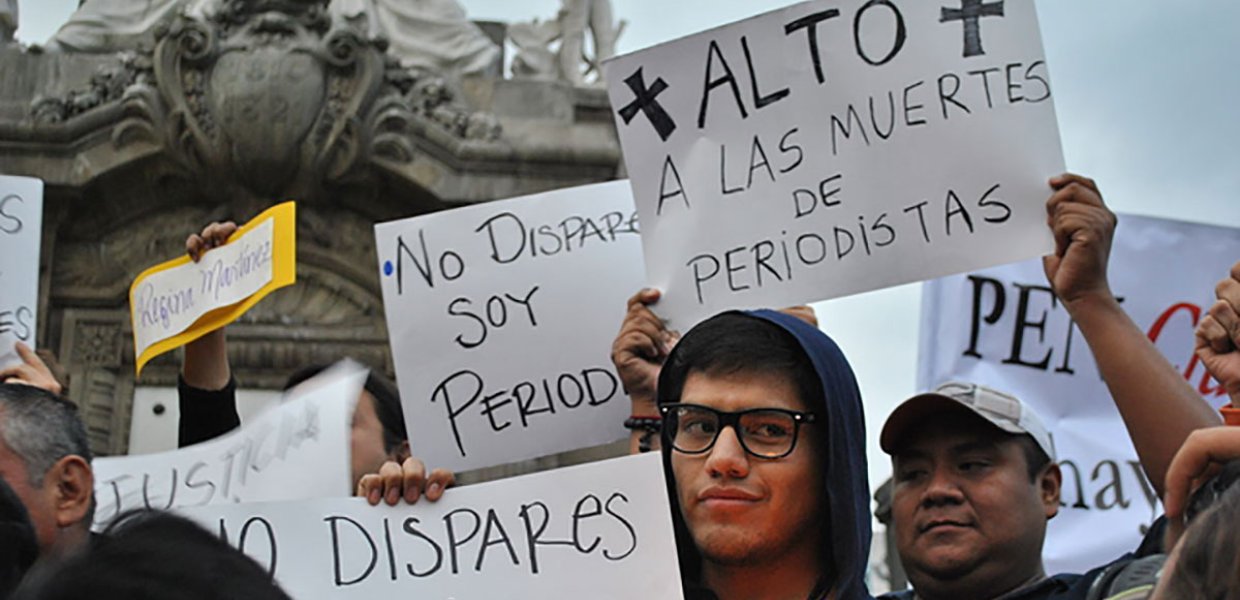 Photo of protestors holding signs that say in Spanish "don't shoot I'm a journalist"