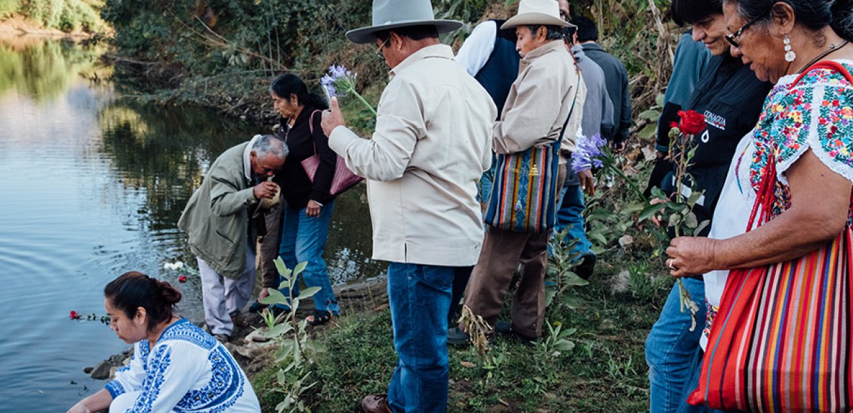 Group of people engaging in spirituality at a pond