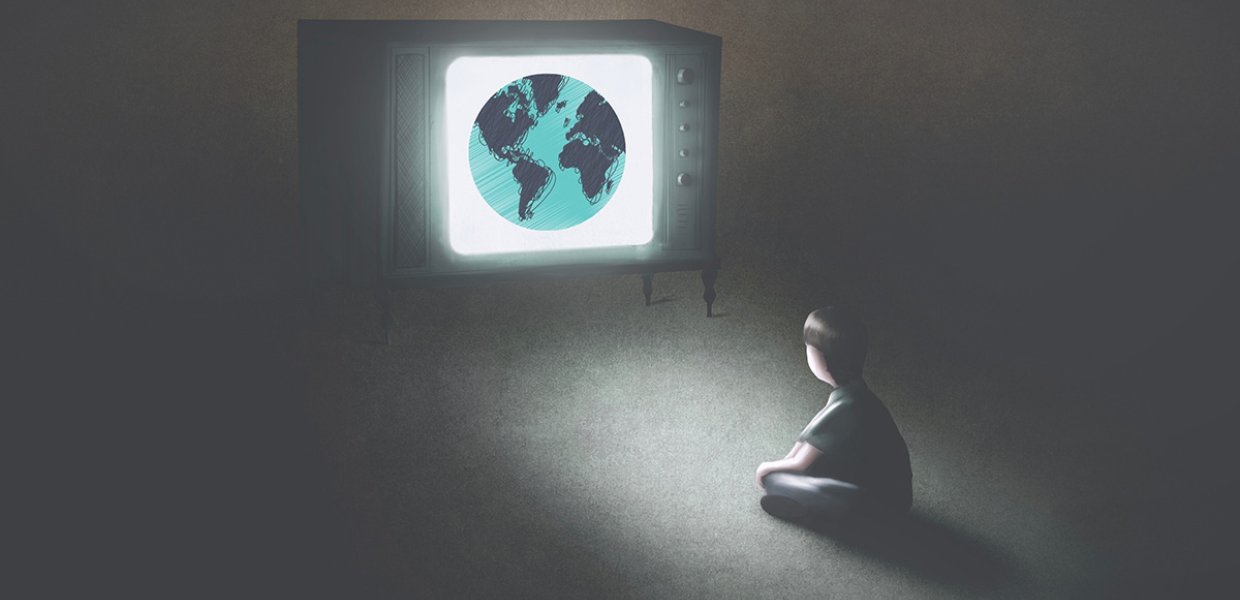 Image of person in a dark room watching a television that shows planet Earth