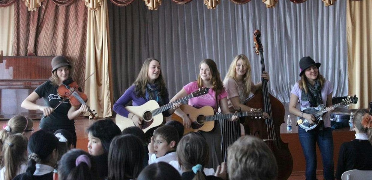 The bluegrass group Della Mae plays at an orphanage in Kyrgyzstan on its State Department-sponsored American Music Abroad tour in 2012. Photo: Paul Rockower