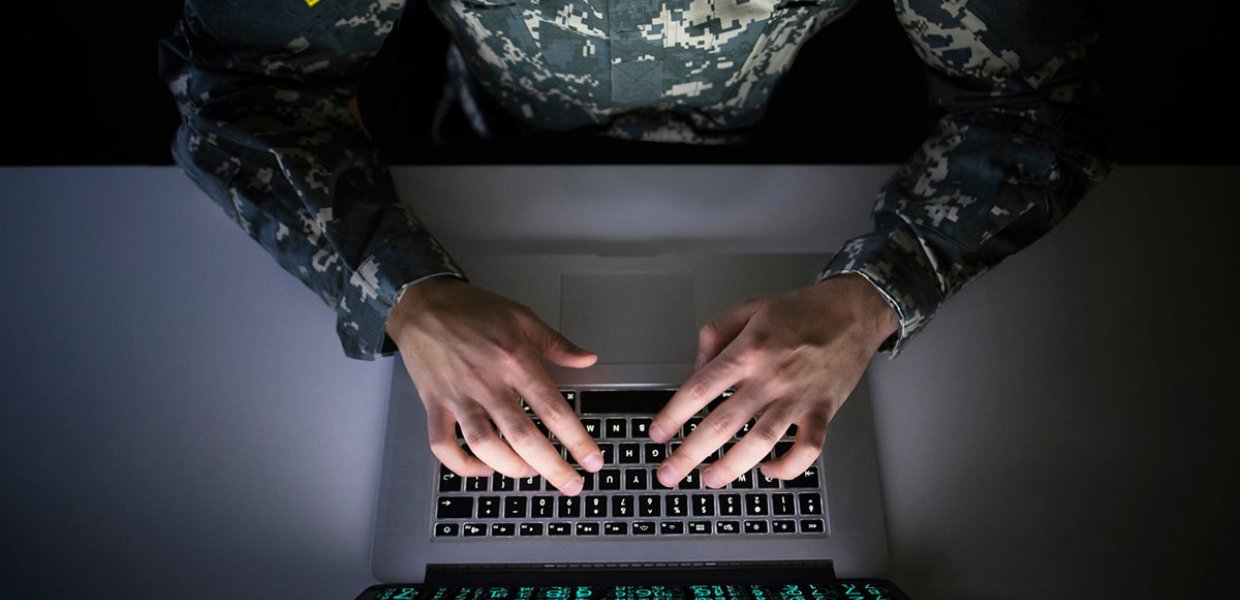 Photo of a person in a U.S. Army uniform typing on a laptop