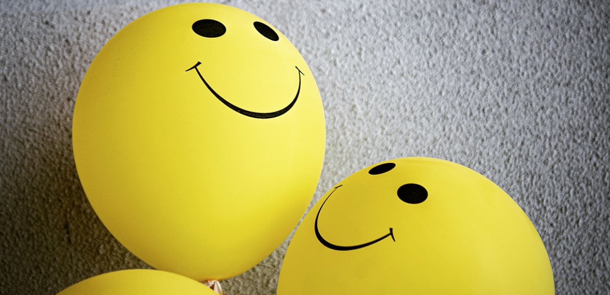 Photo of some yellow balloon with smiling faces on them