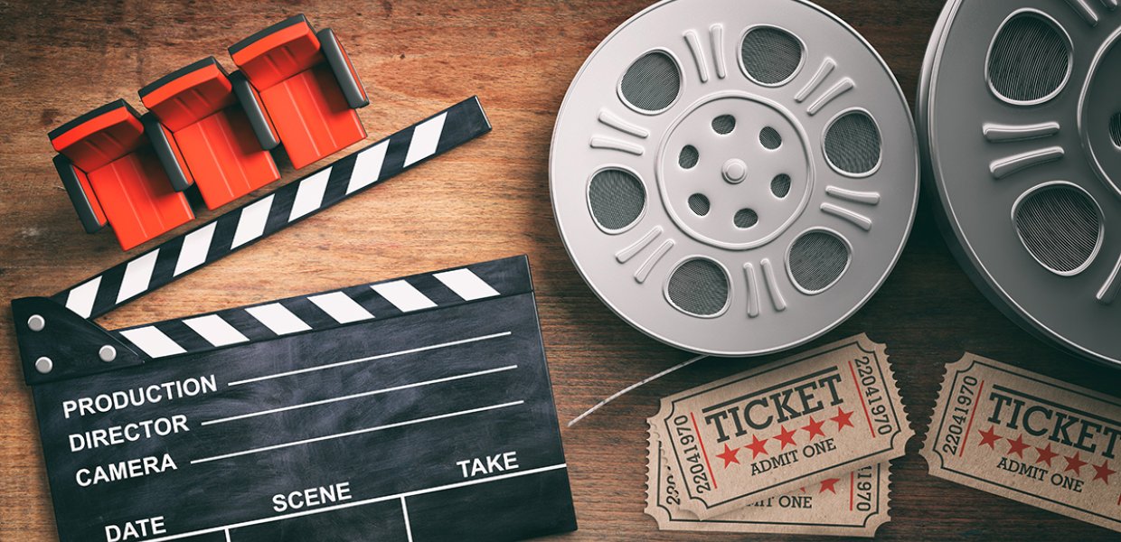 Photo of a film slate, film roll, and movie tickets