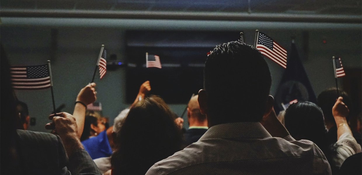 A group of people waving United States of America flags.
