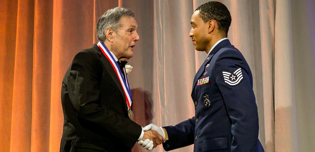 Jeff Cole (pictured left) shakes Air Force officer's hand and receives medal