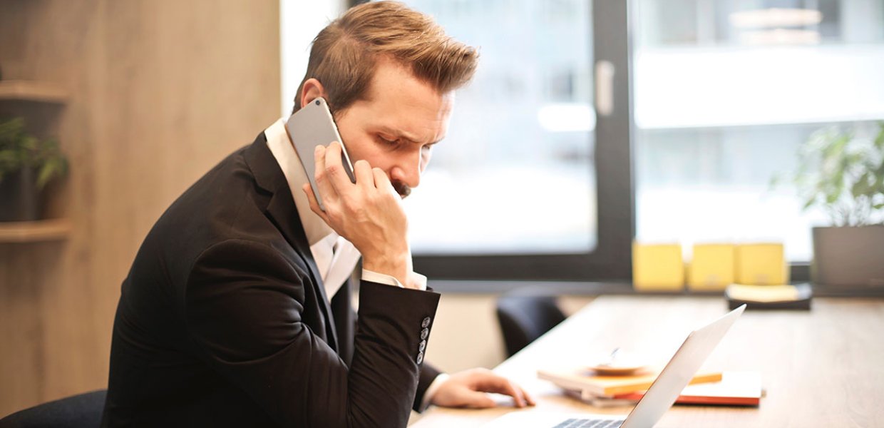 Photo of a person on the phone at a desk