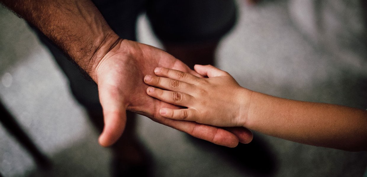 Photo of a person holding a child's hand