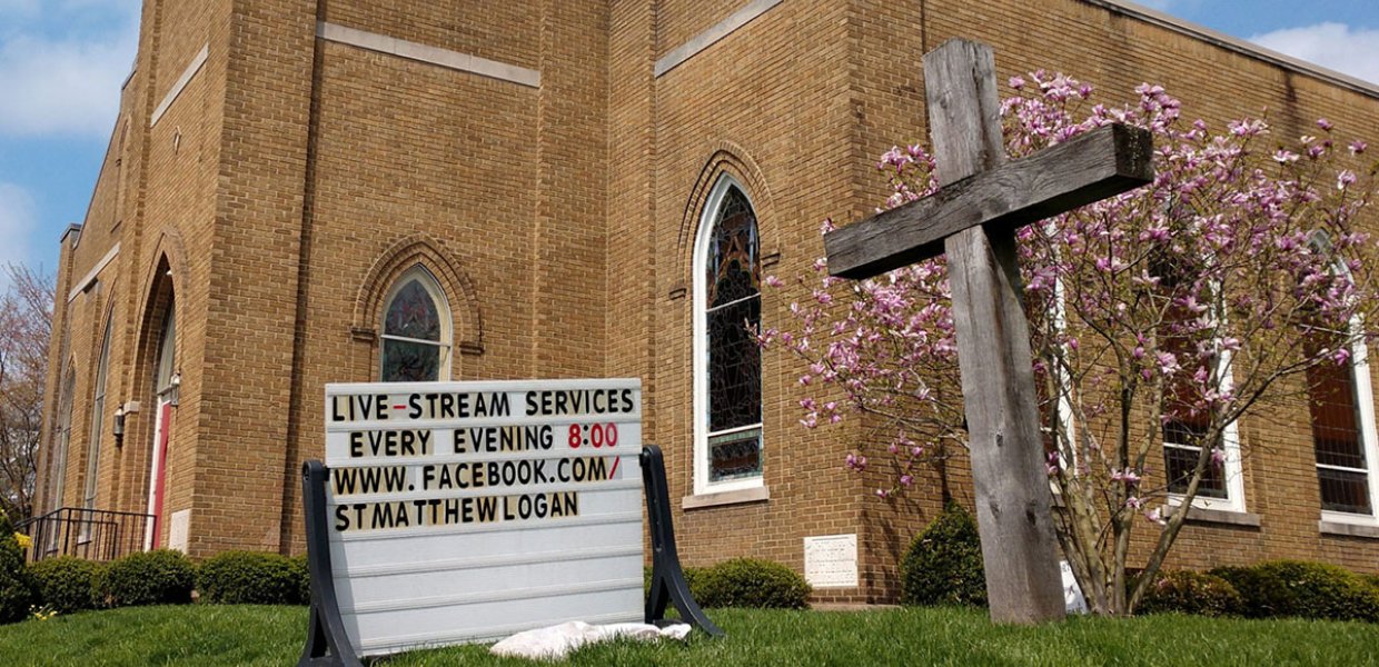 Photo of a worship center with a sign outside that promotes livestreamed remote worship practices
