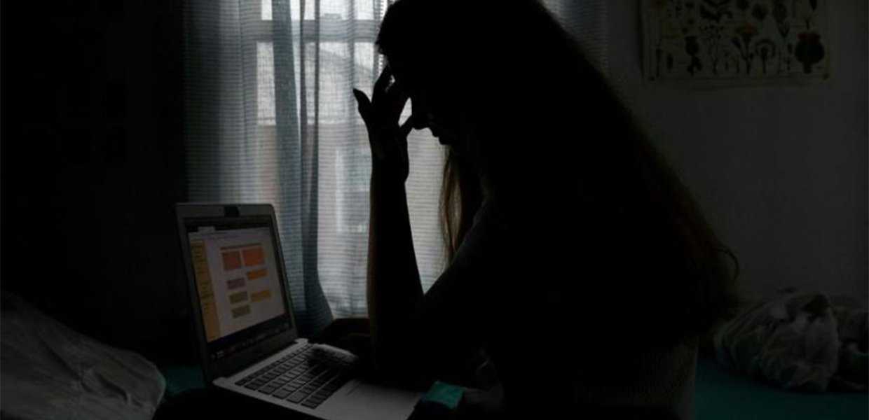 A student in distress looking at a laptop