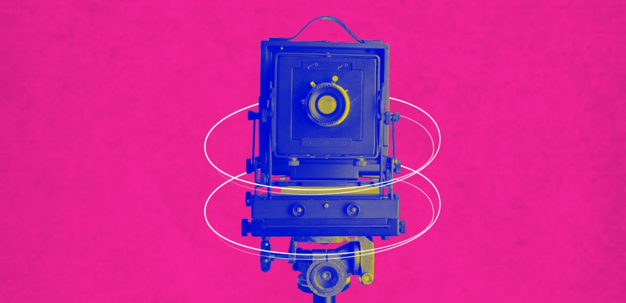 An old fashioned camera on a pink background