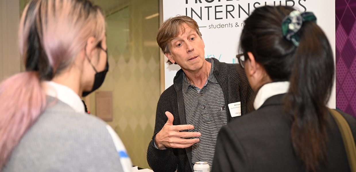 Two students talking to a man in the entertainment industry