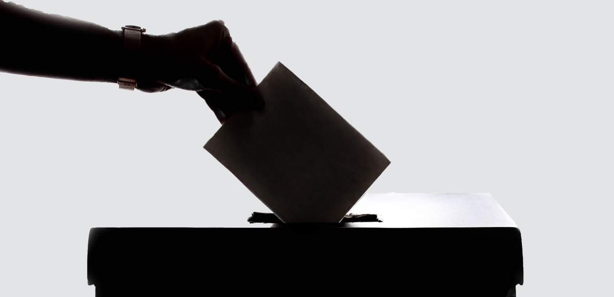 Photo of a person dropping a piece of paper into a box