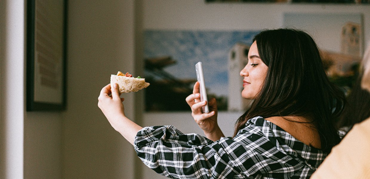 Photo of a person taking a picture of their food