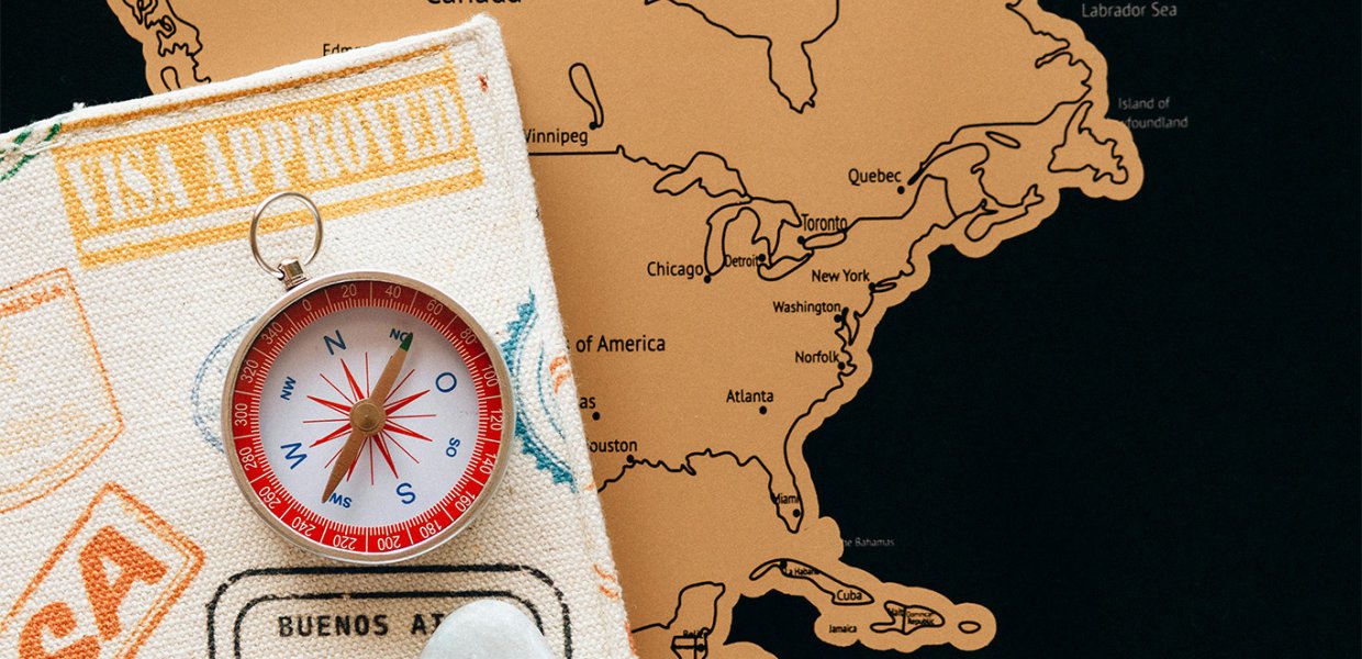 Visa and compass laid atop a map of North America
