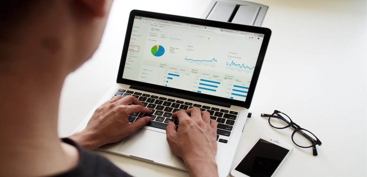 Photo of a person working on bars and graphs on a computer