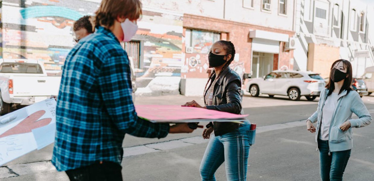 Photo of people holding boards and walking