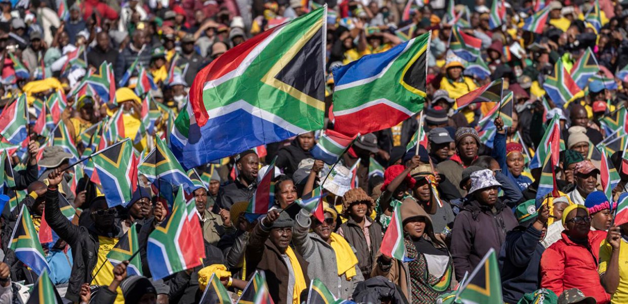 Crowd of people waving the flag of South Africa