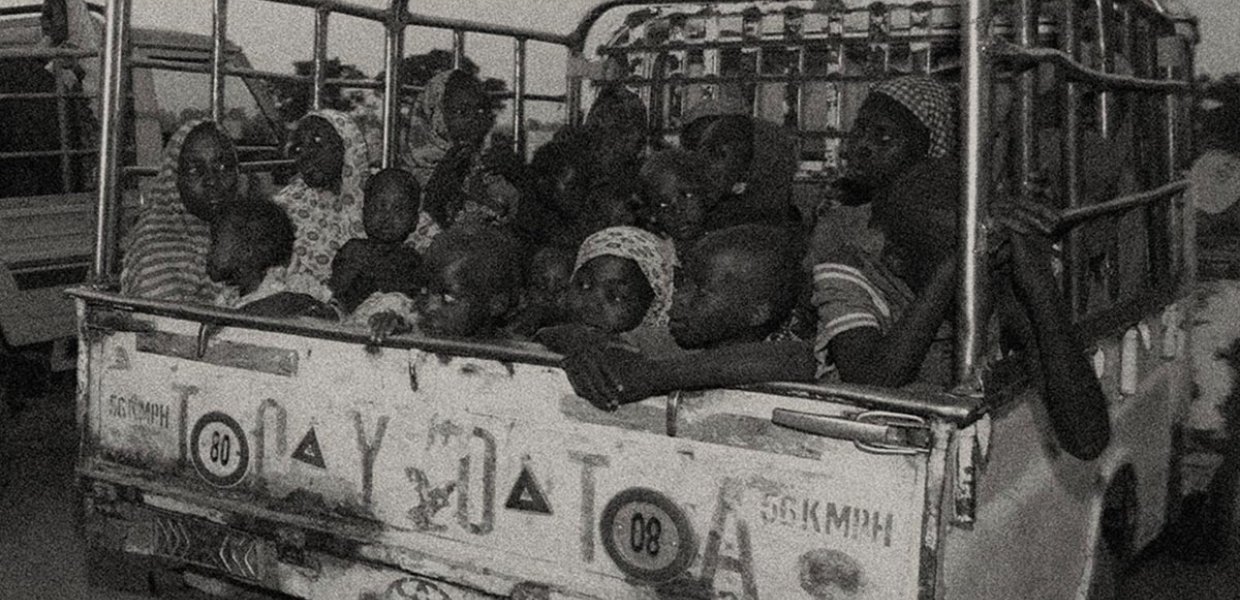 Women and children in a car in Nigeria. Black and white. 