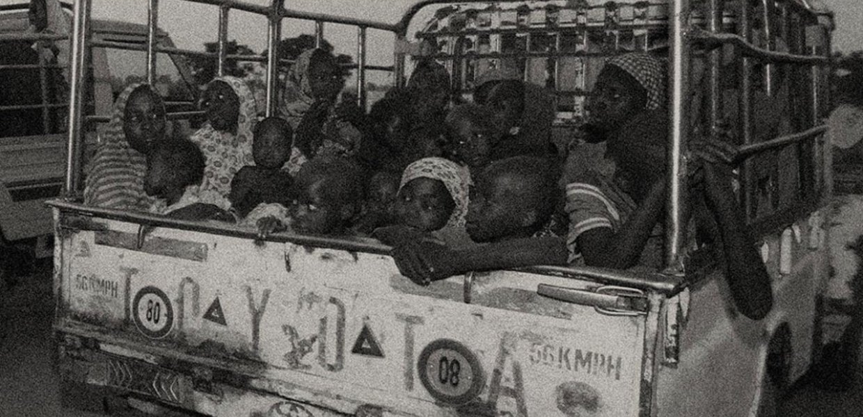 Women and children in a car in Nigeria. Black and white.
