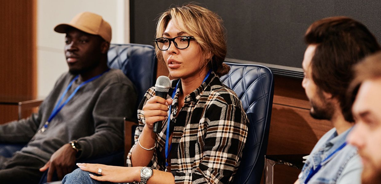 Photo of people speaking in a panel-like setting