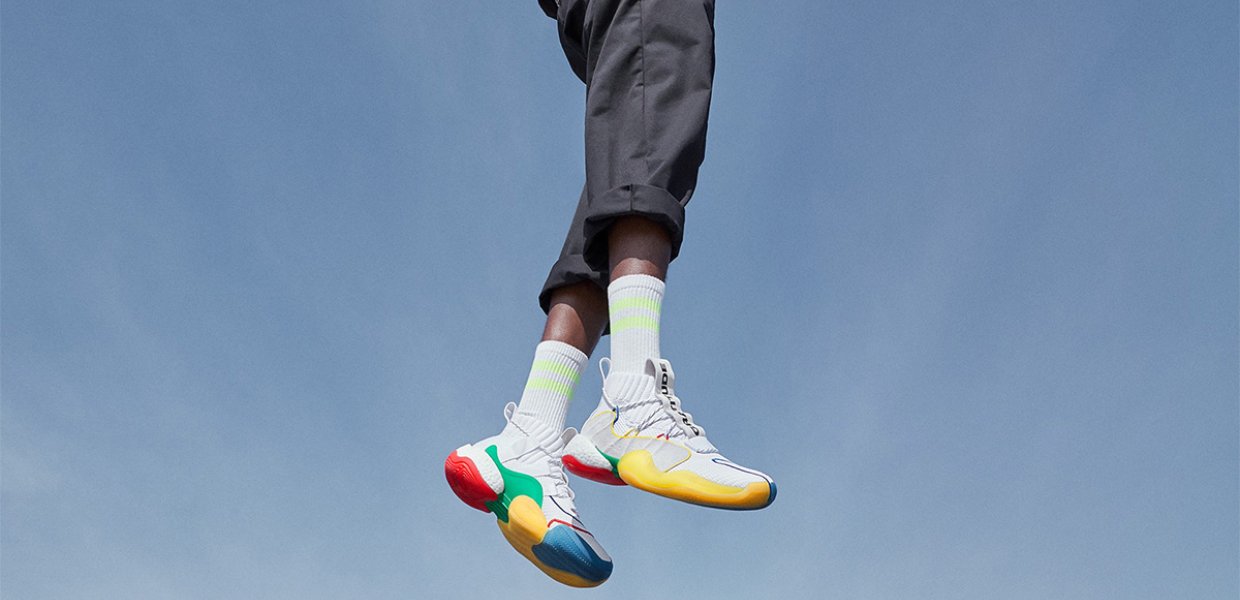 Person wearing colorful shoes and jumping against a blue sky