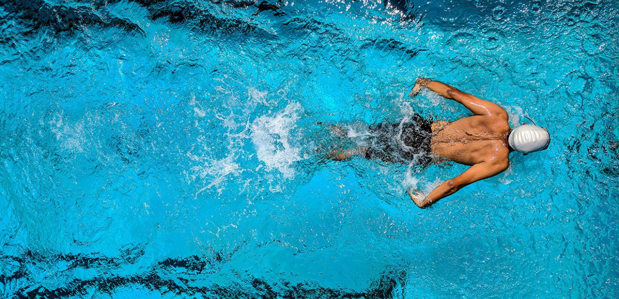 Someone swimming in a swimming pool from above