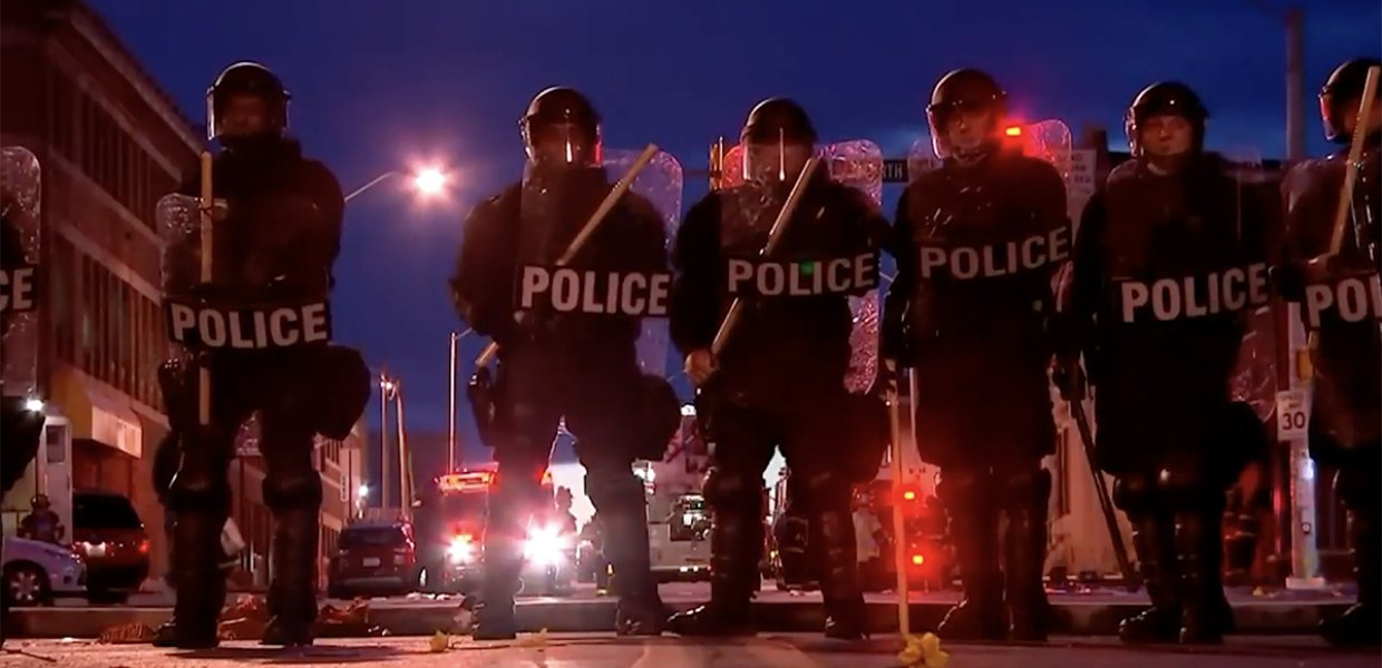 Photo of police in riot gear holding shields