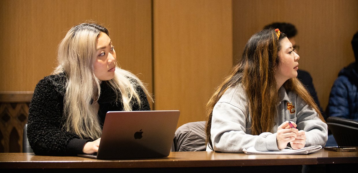 Two people listening to a presentation