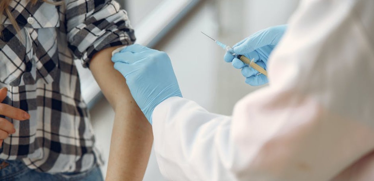 Photo of a person administering a vaccine to another person